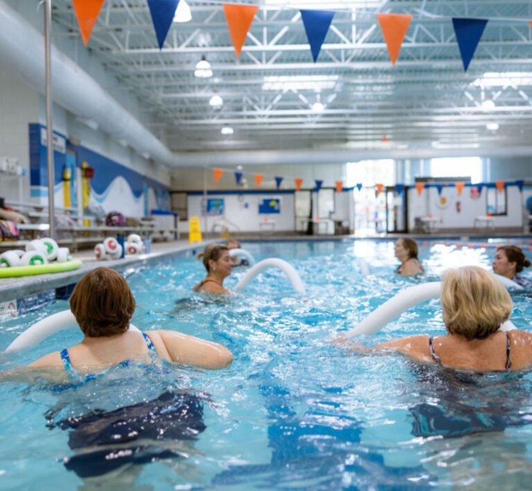 Members participating in an Aqua Fit class at The Workout Club Londonderry using pool noodles for a low-impact water workout.