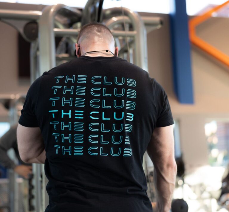 Member wearing The Workout Club branded shirt inside the gym pro shop area