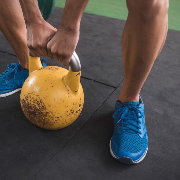 Member using kettlebell during circuit training workout at The Workout Club Salem gym