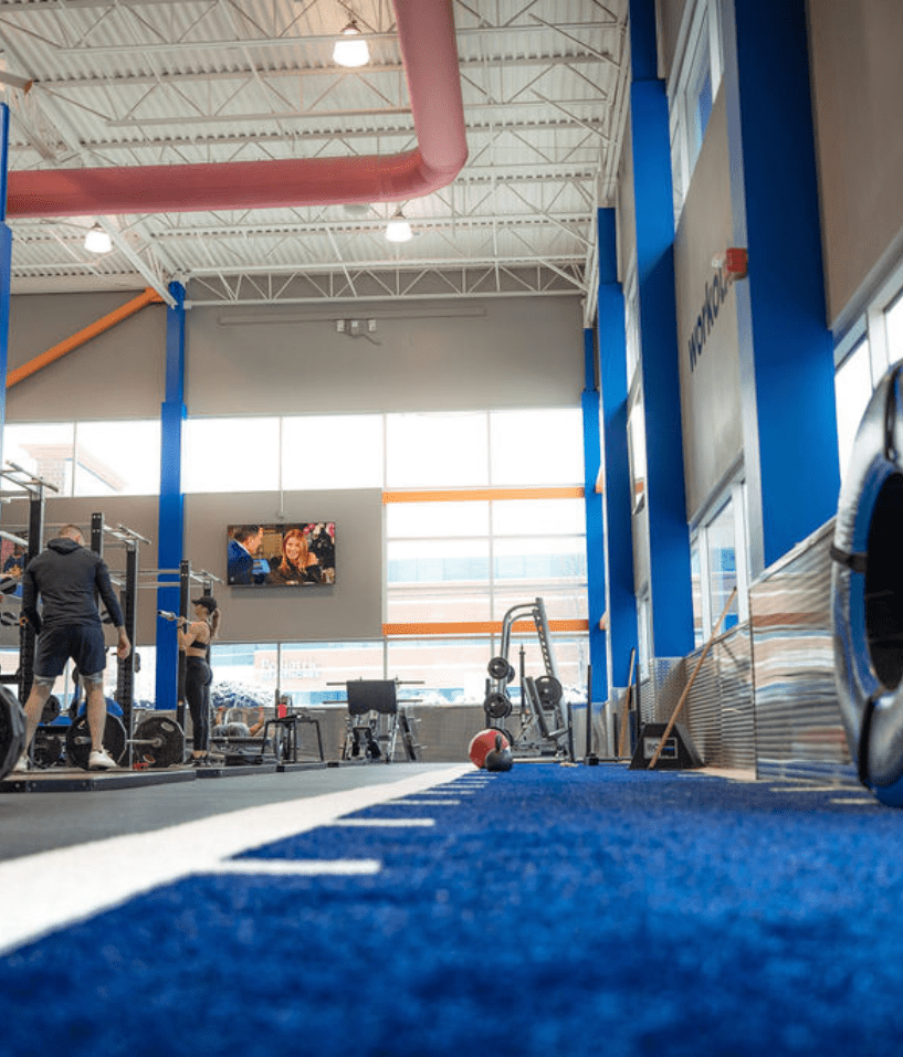 Functional training turf area at The Workout Club in Salem NH, featuring sled push zone, oversized tires, and high ceilings for athletic performance workouts.