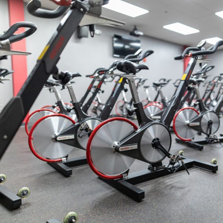 Close-up view of Keiser spin bikes lined up in the indoor cycling studio at The Workout Club Salem in New Hampshire.