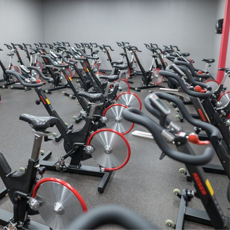 Rows of Keiser indoor cycling bikes in the spin class room at The Workout Club Salem in New Hampshire.