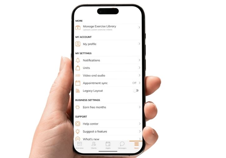 Hand holding a smartphone showing The Workout Club app settings menu for managing account and notifications.